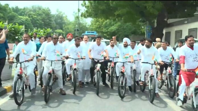 दिल्ली विधानसभा में साइकिल से पहुंचे AAP विधायक, टी-शर्ट विवाद पर 6 मार्शल आउट
